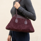 Borsa bordeaux indossata, stile editoriale senza viso